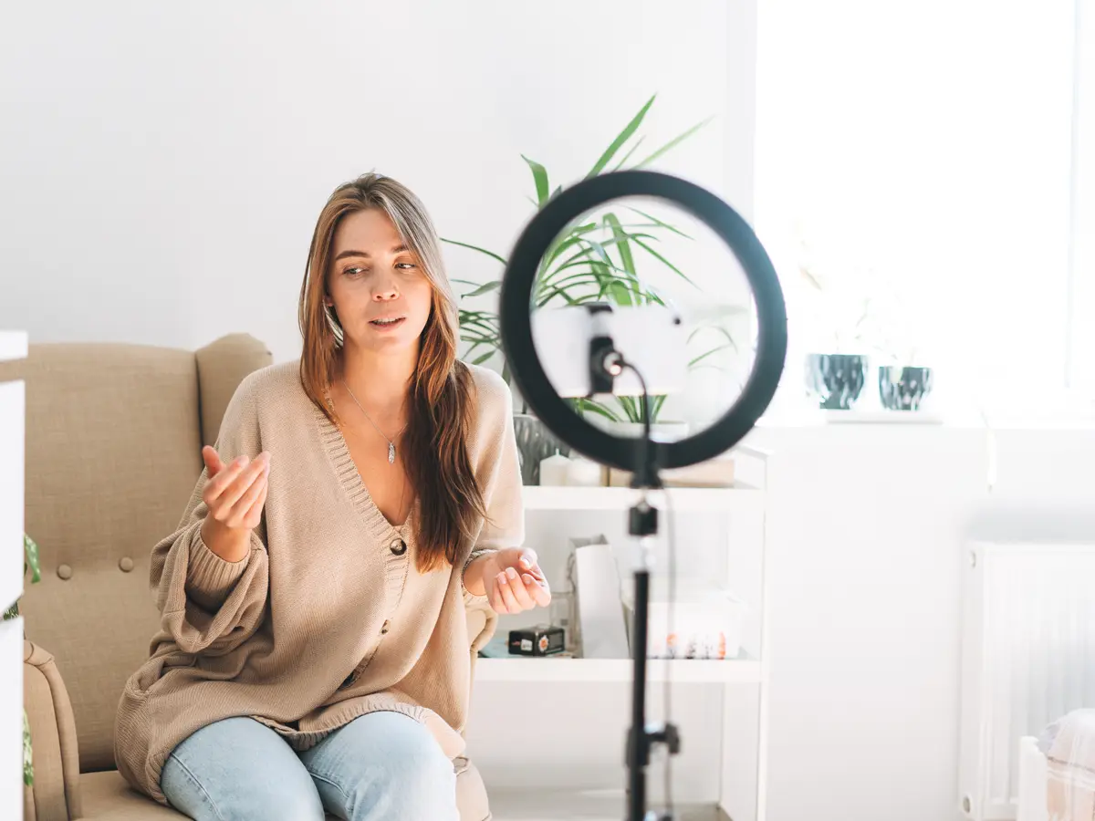 Creator recording a video at home with a ring light and smartphone